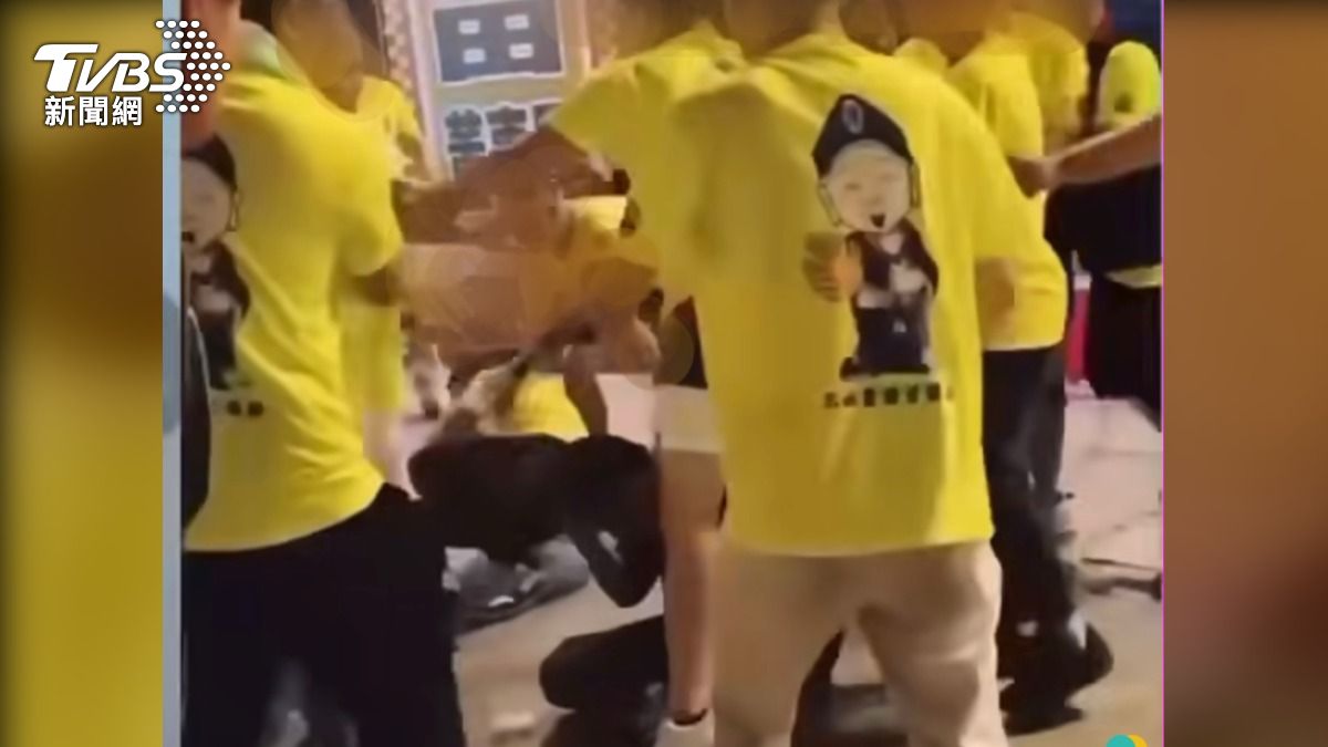 王男(黑衣)被圍毆倒地不起 。(圖/翻攝自網路)