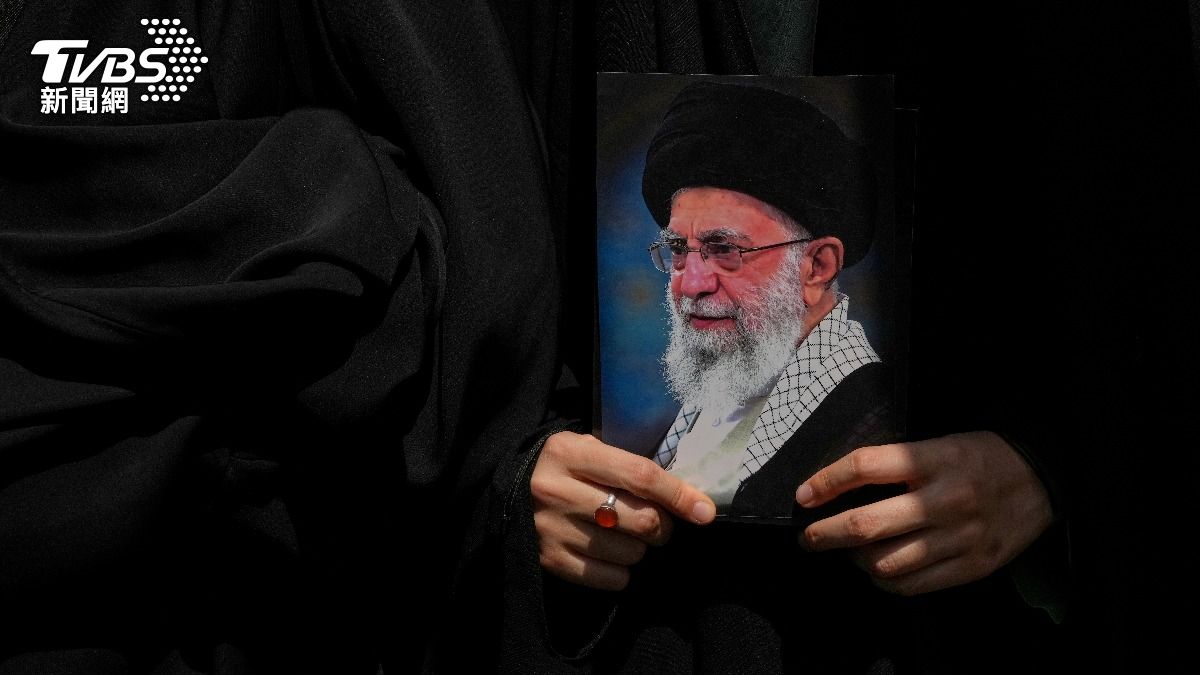 一名德黑蘭民眾手握伊朗最高領袖「哈米尼」(Ali Khamenei)的照片,距離上次哈米尼6月18日露臉講話已逾一個禮拜,以伊停火後他持續神隱至今仍未公開現身。(圖/達志影像美聯社)