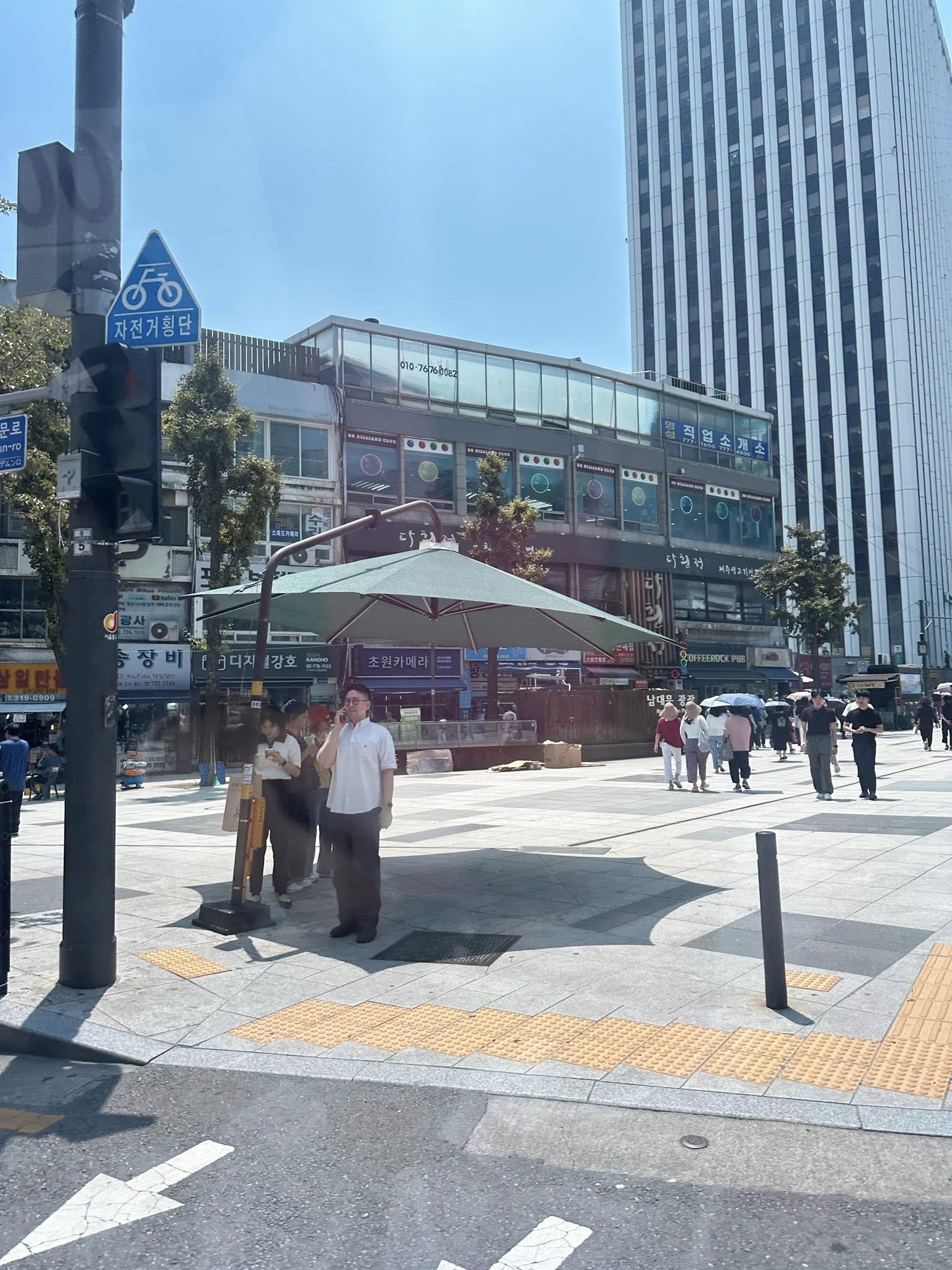 除了遮陽傘,路口地上也有行人號誌燈,方便民眾檢視能否通行。(圖/翻攝自郁方臉書)