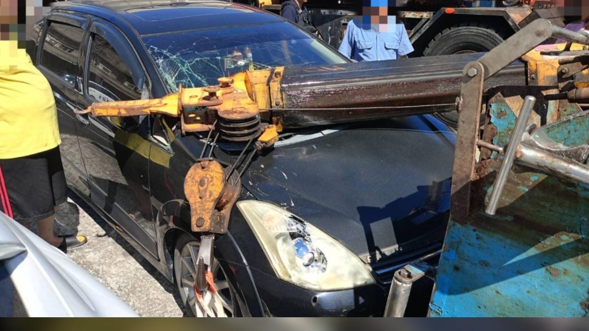 吊車重心失衡側翻!吊臂砸毀轎車車頭。(圖/警方提供)
