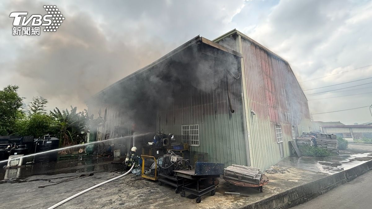 西屯區水尾巷的工廠遭遇火勢,鐵皮屋濃煙猛竄,廠房有火勢冒出。(圖/TVBS)