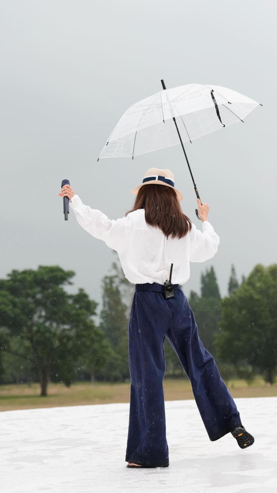 田馥甄彩排時遇到下雨,撐起傘繼續開心高歌。(圖/翻攝自田馥甄臉書)