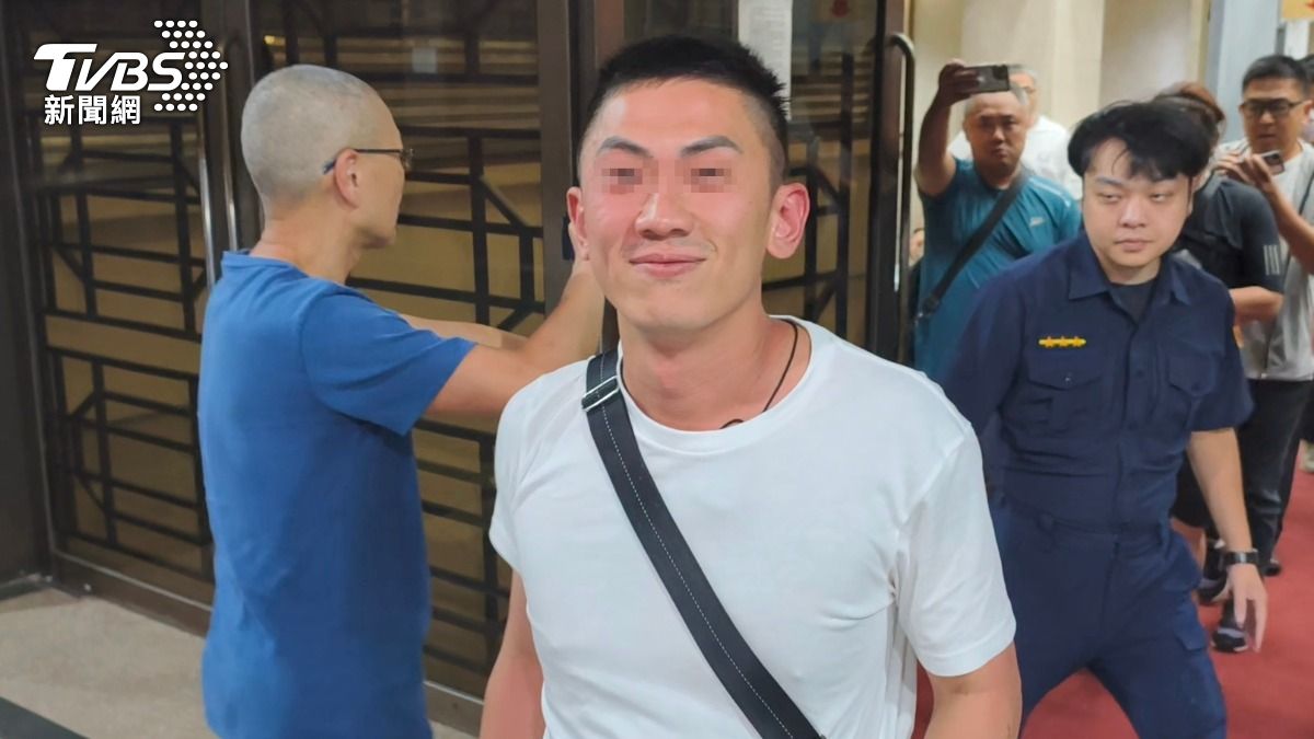 洪明全交保步出法警室時,現場他的一名白衣友人疑酒醉滿臉通紅,不斷推擠在場記者還揮拳打人。(圖/陳冠宇攝)