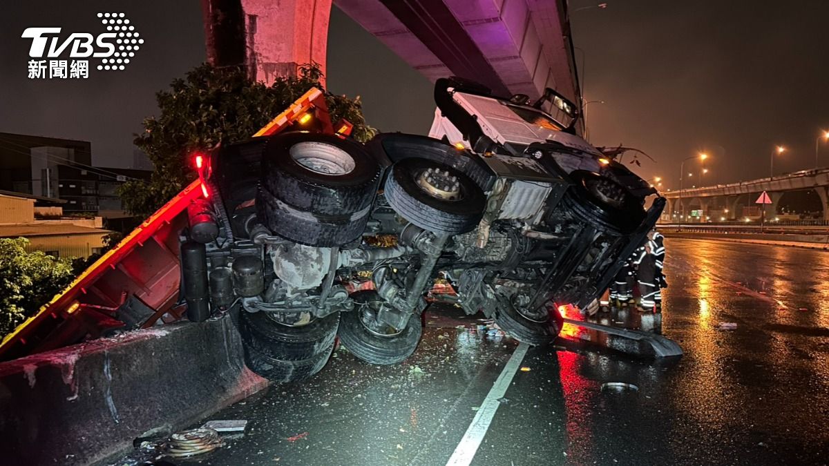 營聯結車自撞護欄,車身側翻懸掛。(圖/TVBS)