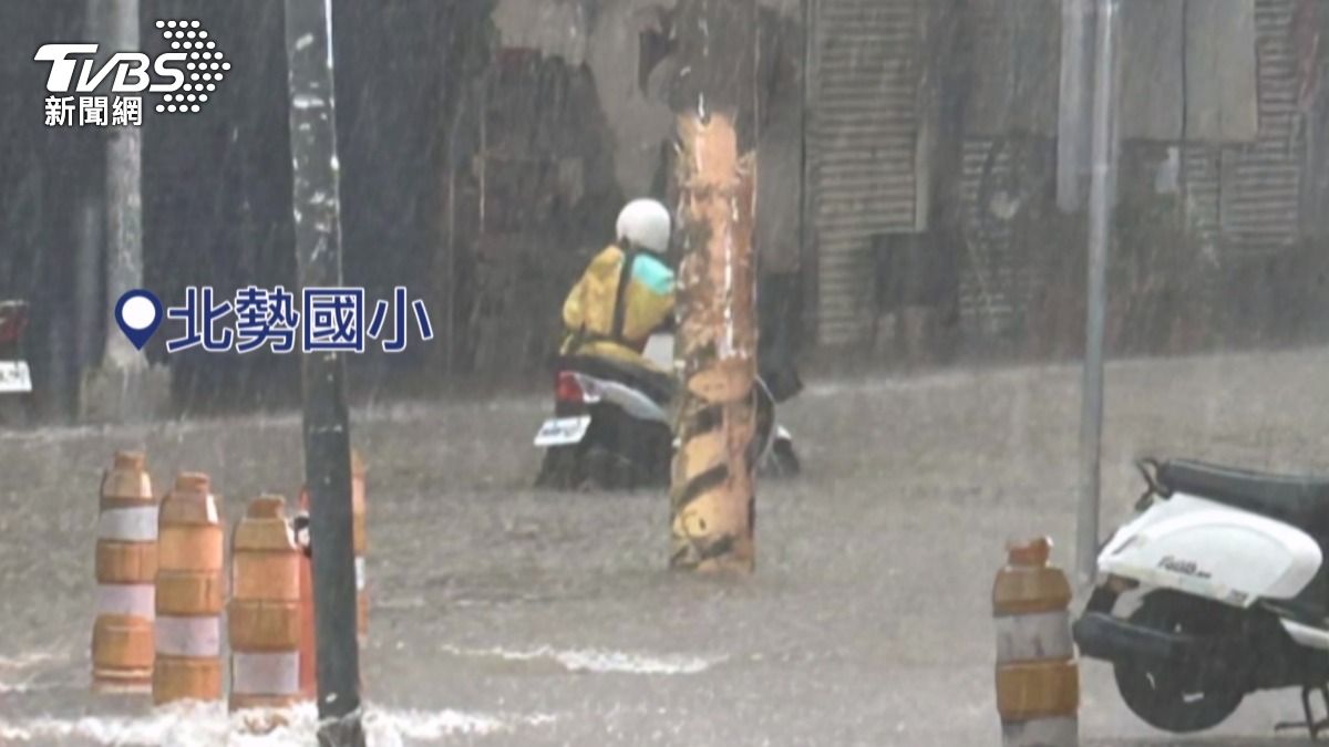 北勢國小前,民眾牽著機車涉水。(圖/畫面翻攝 Facebook 沙鹿之美)