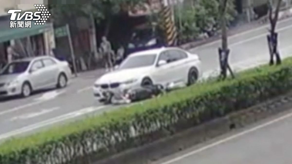 機車騎士被白車拖行輾過。（圖／TVBS）