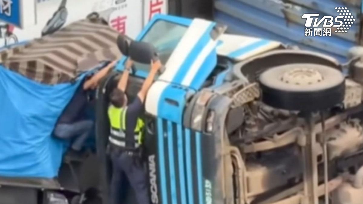 貨車駕駛受困,警民爬上車頭「抓後照鏡」成功救援。(圖/內壢大小事臉書)