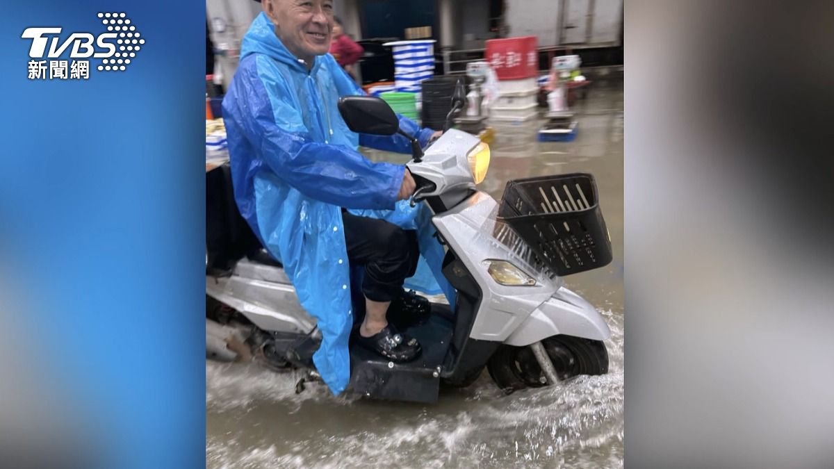 前鎮漁港早市變成了水上市場,機車經過濺起水花,攤販和民眾克難泡水買水產。(圖/記者爆料網)
