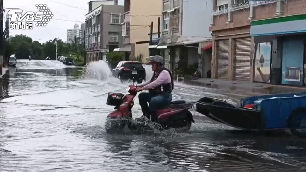 屏東東港東津里路面積水,車輛經過濺起大片水花,機車瞬間變成水上摩托車。(圖/TVBS)