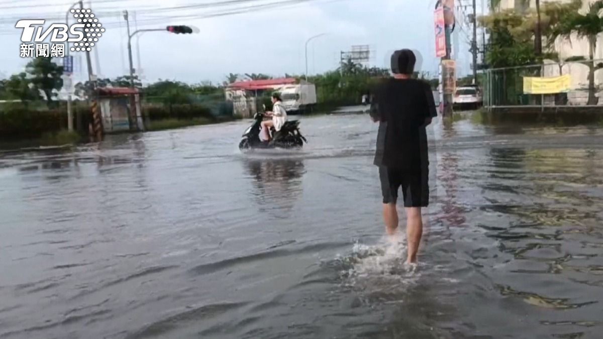 東港街道積水已達腳踝高度,車輛經過時濺起大片水花。(圖/TVBS)