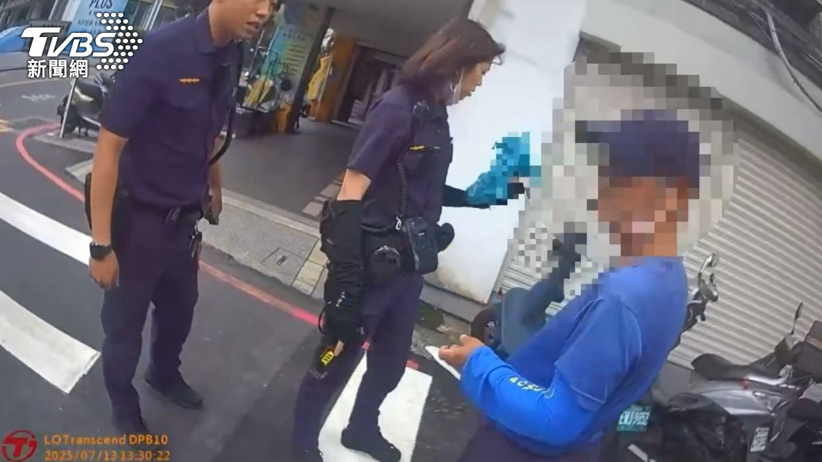 李姓男子持刀在大馬路上閒晃，員警趕抵現場將其攔截逮捕。（圖／TVBS）