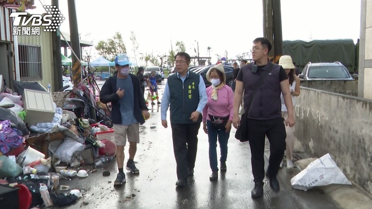 黃偉哲13日再到七股西寮里視察慰問災民，都能看到粉衣女志工跟在一旁。（圖／TVBS）