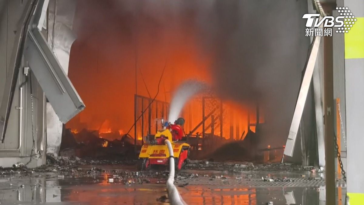 現場不時傳出爆炸聲，消防人員無法冒險進入，只能派遣消防機器人入內灑水降溫。（圖／TVBS）