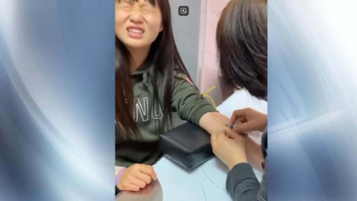 影片中可見學生露出害怕表情，抽血者手指直接接觸針頭。（圖／簡奇陞Threads）