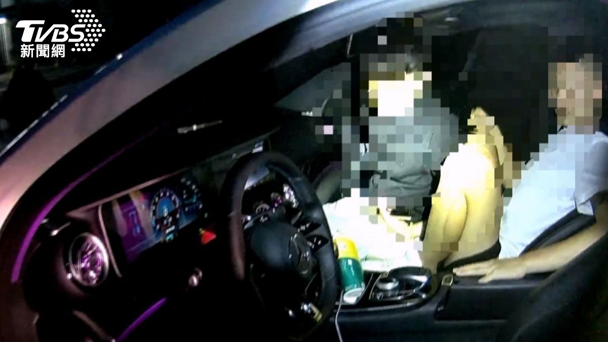 當員警上前查看並打開車門時,發現車內兩名男子疊坐在副駕駛座上。(圖/TVBS)