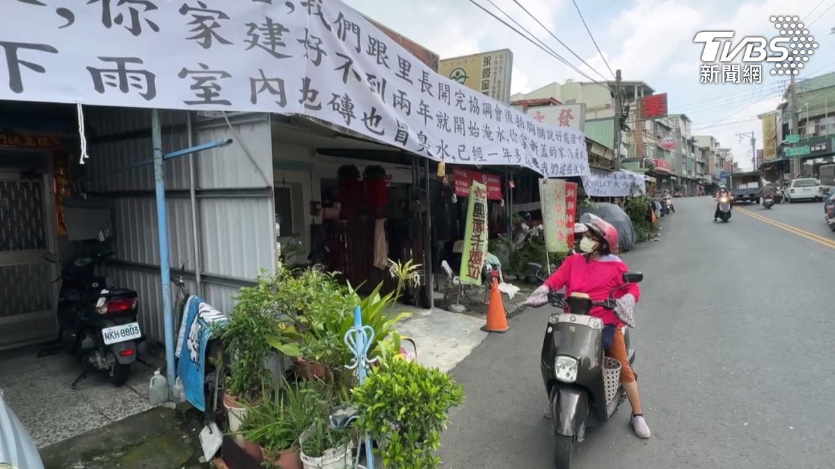 高雄大樹的居民指控,因為鄰居整修,逢雨必淹,氣得拉起整面抗議布條。(圖/TVBS)