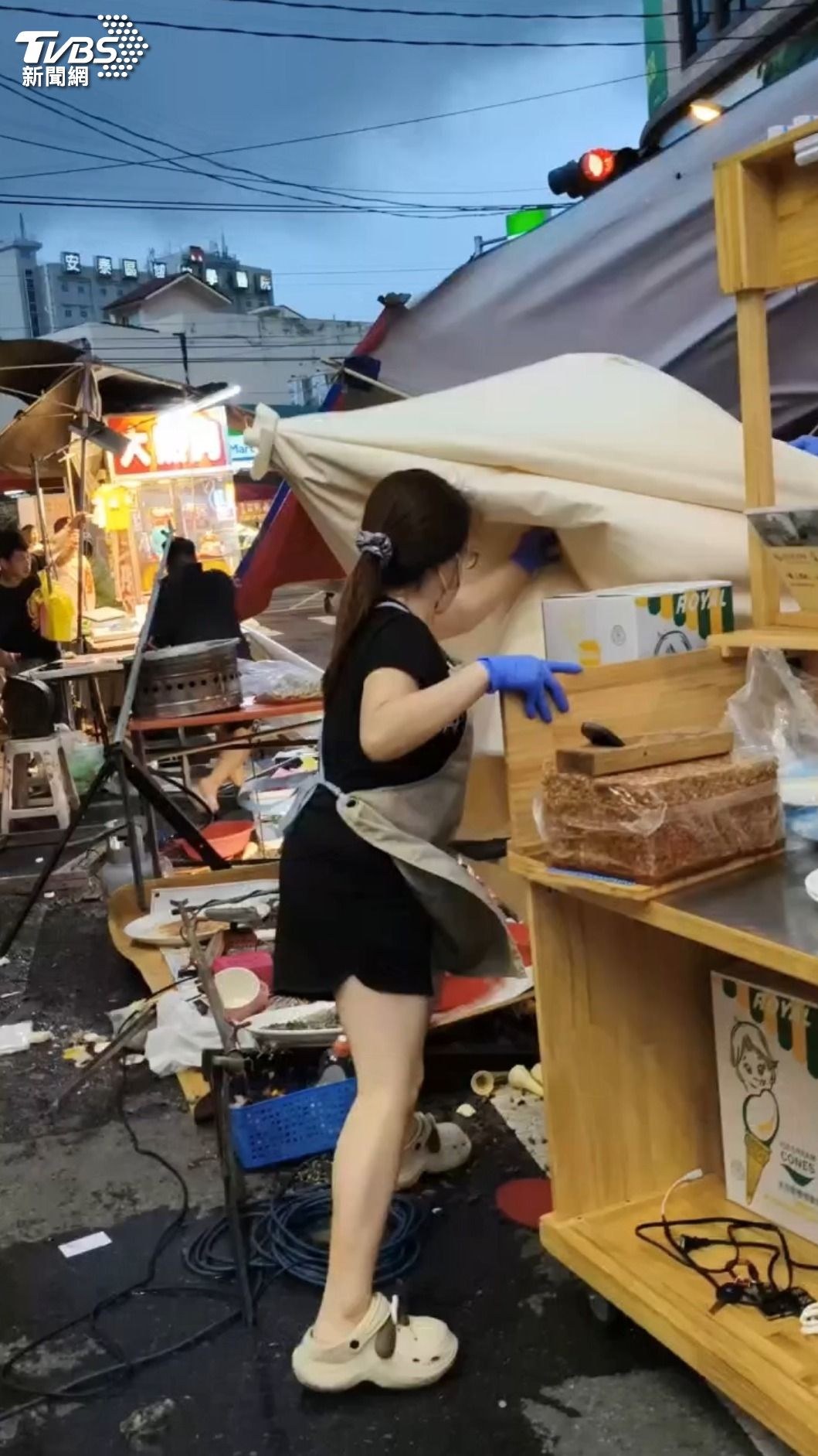 屏東東港夜市出現8級強陣風,導致攤位與遮陽傘東倒西歪,商品散落一地。(圖/TVBS