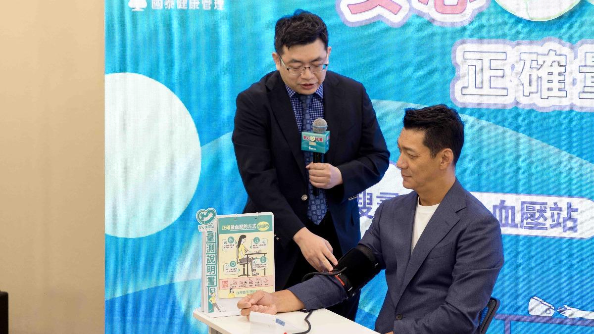 高血壓學會林彥宏理事長與聶雲展示正確血壓測量方式。(圖/國健署提供)