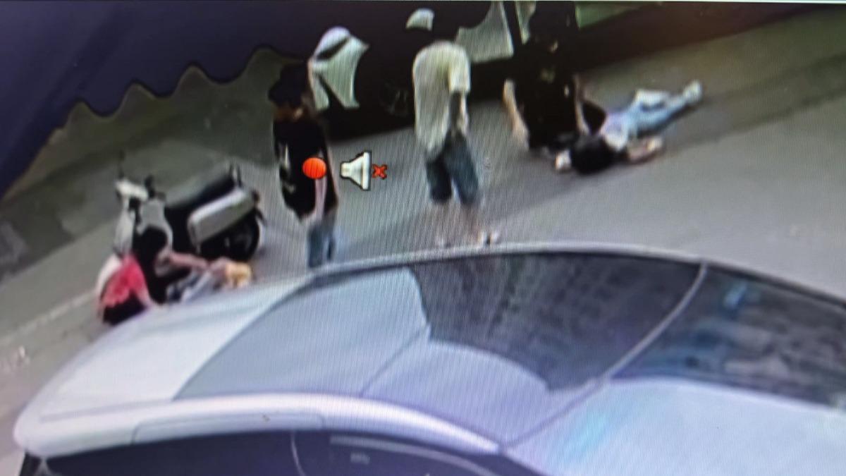 被撞騎士躺在地上，路人上前關心。(圖／民眾提供)
