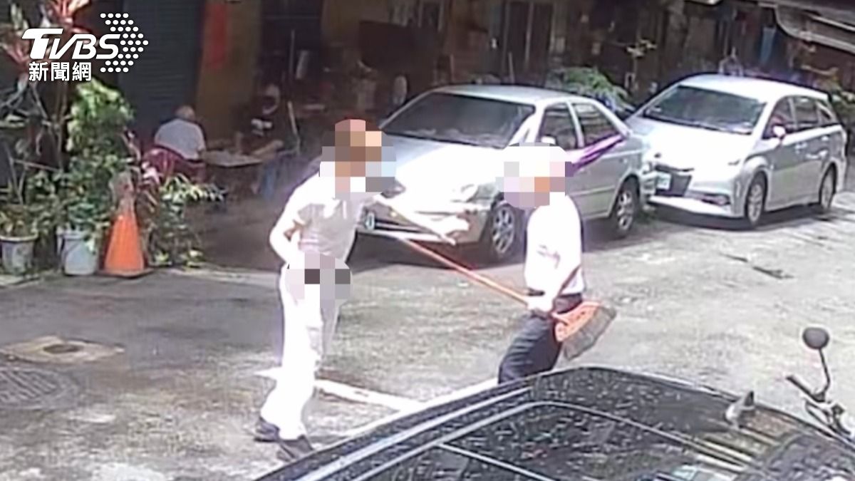 兒當街持刀追砍父,父持掃把、雨傘防衛。(圖/TVBS)