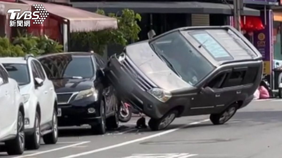 休旅車「騎上路邊車」,右半邊車身懸空 。(圖/TVBS)