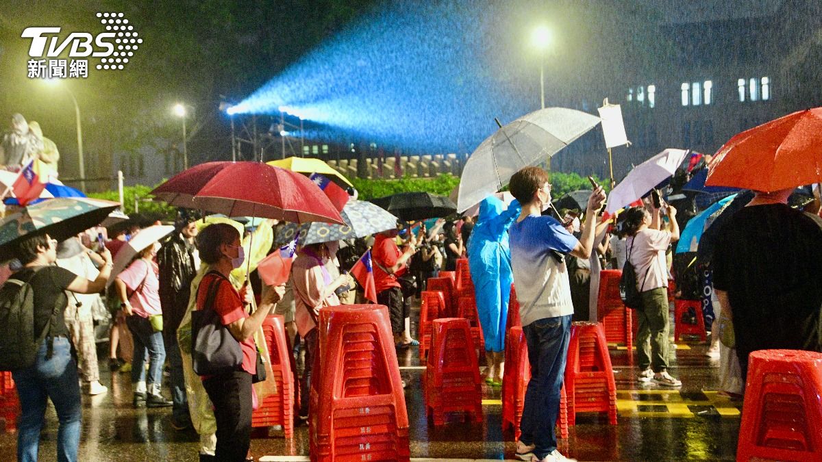 藍營「不同意罷免」選前之夜下大雨，結束後支持者撐傘仍不散。（圖／胡瑞麒攝）