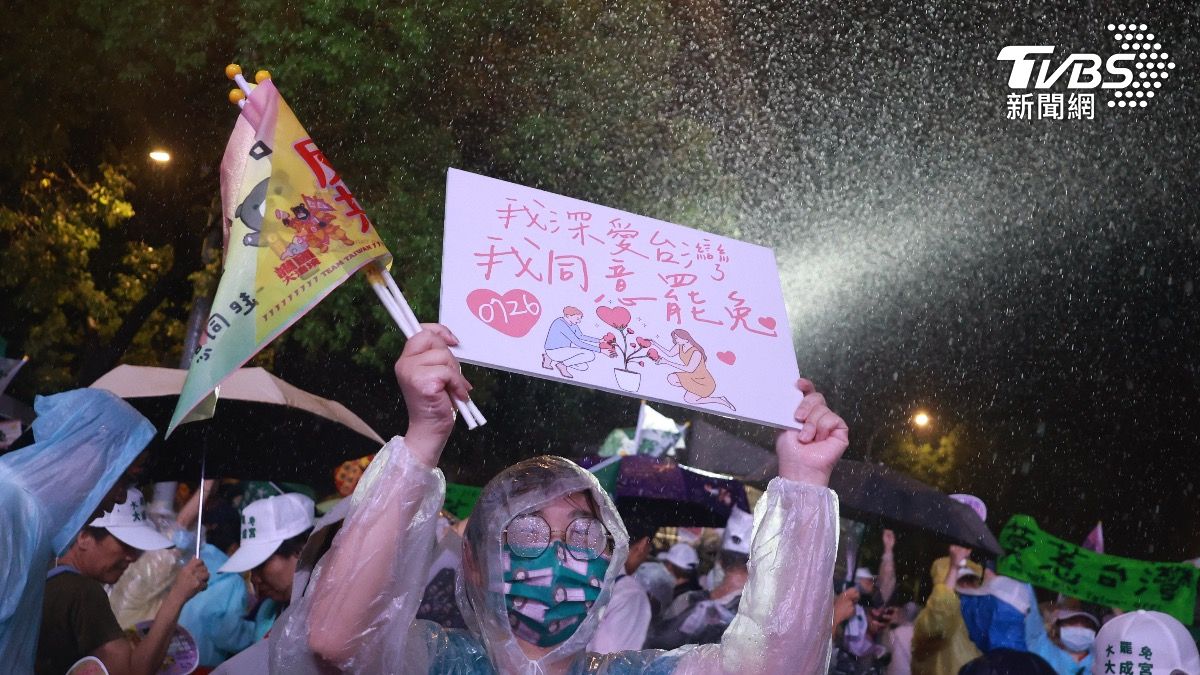 民眾在大雨中高舉「我深愛台灣，我同意罷免」。（圖／華子琛攝）