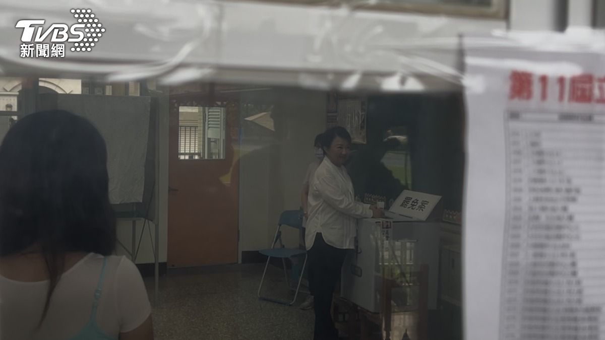 盧秀燕今日一早9時抵達北區健行國小投票，她撐傘走在雨中，面帶微笑神情輕鬆。（圖／林冠丞攝）