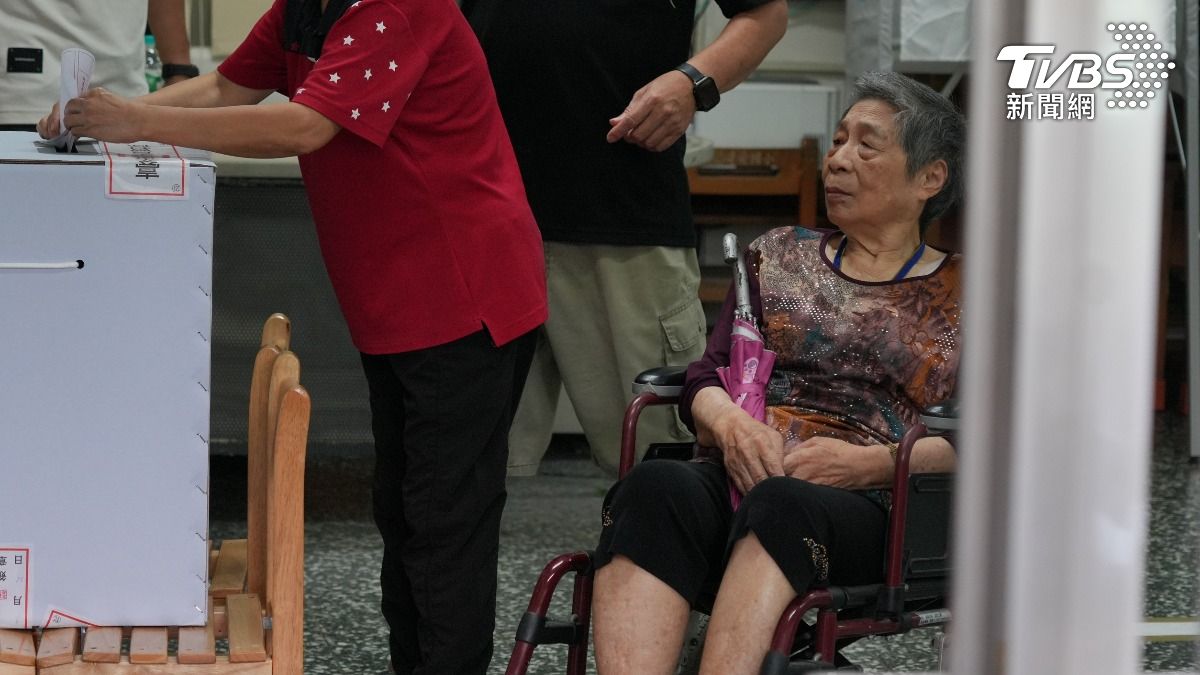 有不少長者由家人攙扶或是推著輪椅也要到場投票。(圖/區國強攝)