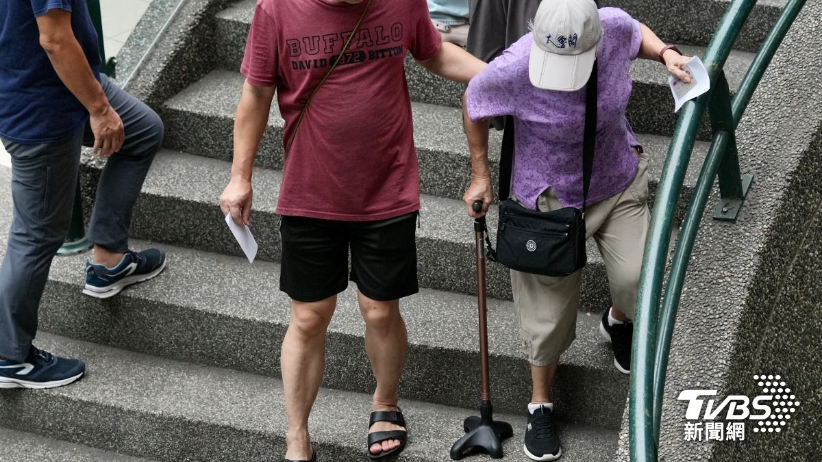 有不少長者由家人攙扶或是推著輪椅也要到場投票。(圖/區國強攝)