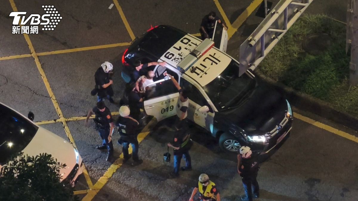 即使在上警車前,潘男仍不斷辱罵警方,怒嗆「你們是民進黨的狗」。(圖/陳冠宇攝)