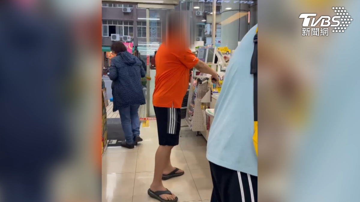 一名身穿橘衣的男子因不滿被要求排隊,對著店員和其他顧客大聲咆哮。(圖/TVBS)