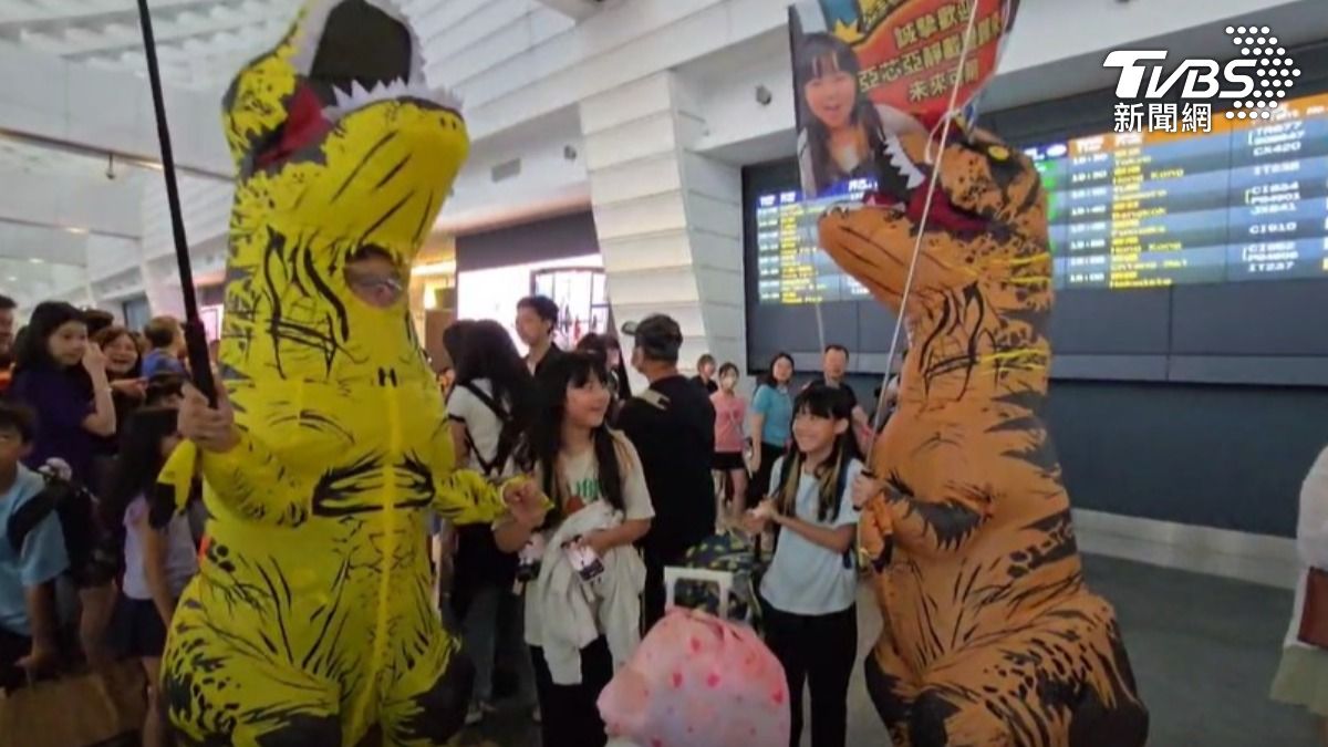 台北市的吳姓夫妻,為了給雙胞胎女兒驚喜,特地穿上暴龍裝。(圖/TVBS)