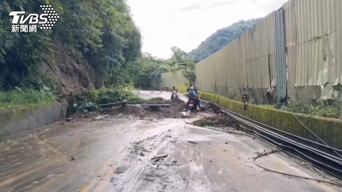面對無法通行的道路，土堆中踩出一條路，協力將機車抬起向前移動。(圖／TVBS)