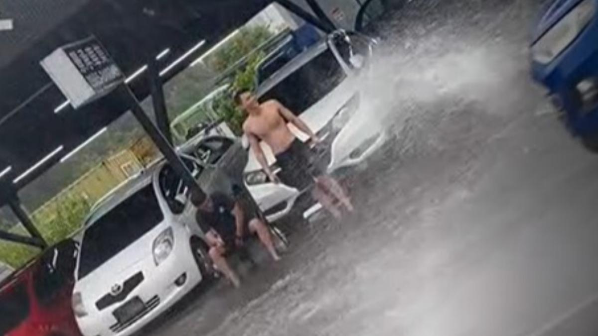 花蓮中央路道路積水成小河,民眾脫衣坐路邊玩水。(翻攝自Threads@alan_8190)