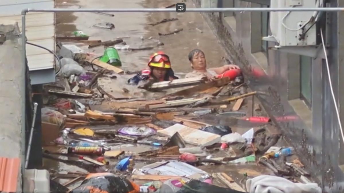 天津消防人員游進洪水中,帶救生圈將差點被淹沒的婦人救出。(圖/CCTV+)