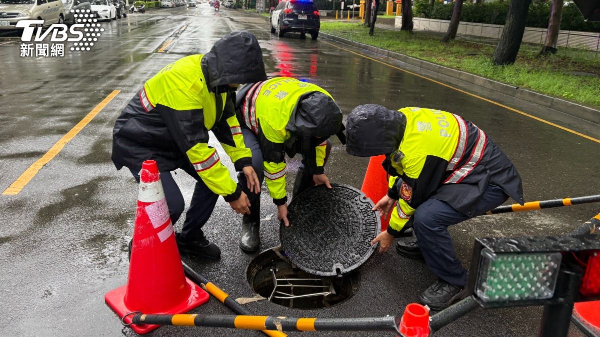 第四分局警方也合力將浮起人孔蓋重新固定,防止再次浮動。15分鐘內恢復路面平整。(圖/TVBS)