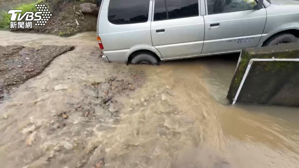 農路變成水路，有居民將車停放在斜坡上，車輛後輪被土石包圍。(圖／TVBS)