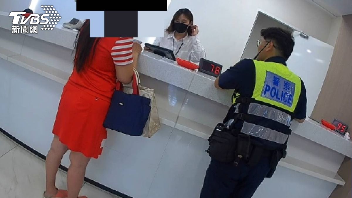 身著亮眼紅衣的徐姓女子，一看到警察，就激動直喊「我不要辦240萬元轉帳了」。（圖／TVBS）