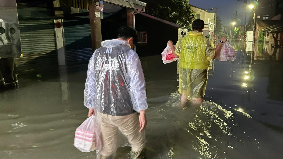 民進黨立委郭國文與立委林俊憲，涉水沿路發便當給受災戶。(圖／郭國文臉書)