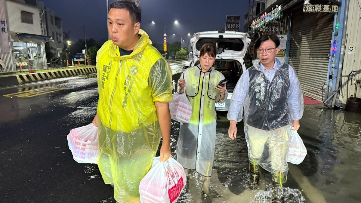 民進黨立委郭國文與立委林俊憲，涉水沿路發便當給受災戶。(圖／郭國文臉書)