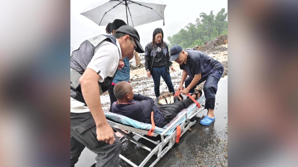 醫護人員不畏風雨與危險路況，以徒步揹負、抬擔架等方式成功將患者接駁下山。(圖／民眾提供)