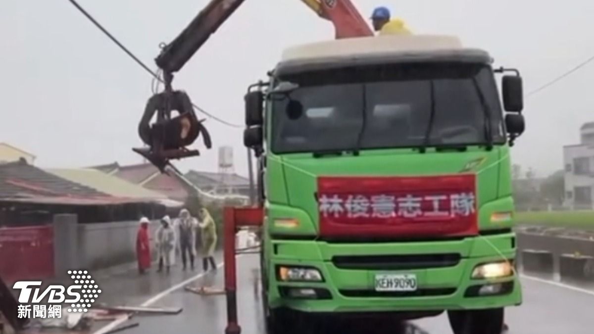 吊車協助災民清理雜物,上頭掛著紅布條註明為「林俊憲志工隊」。(圖/林俊憲threads)