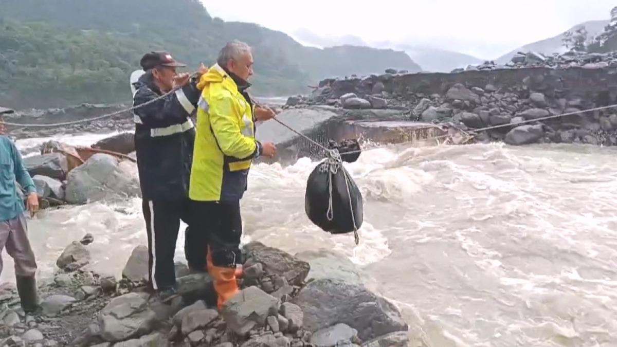 高雄桃源區居民眾人合力拉繩索,將這些生活必需品送到溪水暴漲的對岸。(圖/桃源復興里長提供)