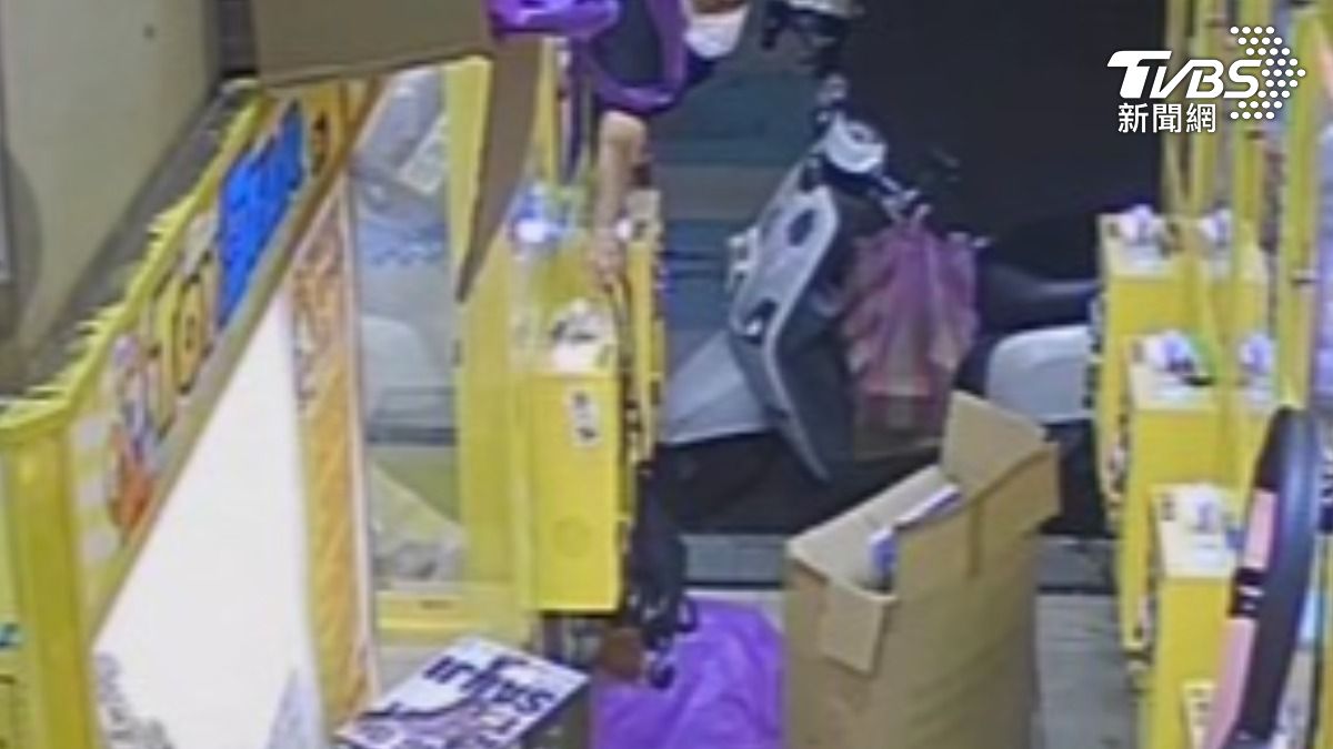 男子探頭進夾娃娃機店，伸手偷走機台邊的包包。（圖／TVBS）