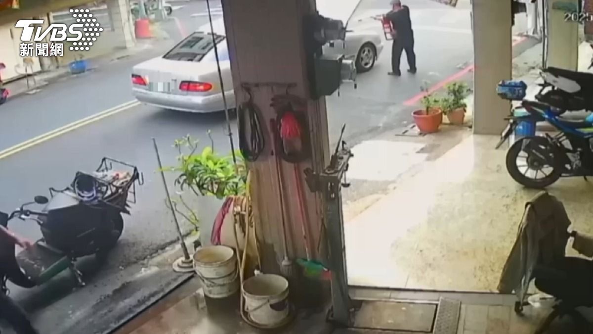 轎車突竄大火,一旁煤氣行老闆急忙拿出滅火器來救援,所幸沒有釀成大災。(圖/TVBS)