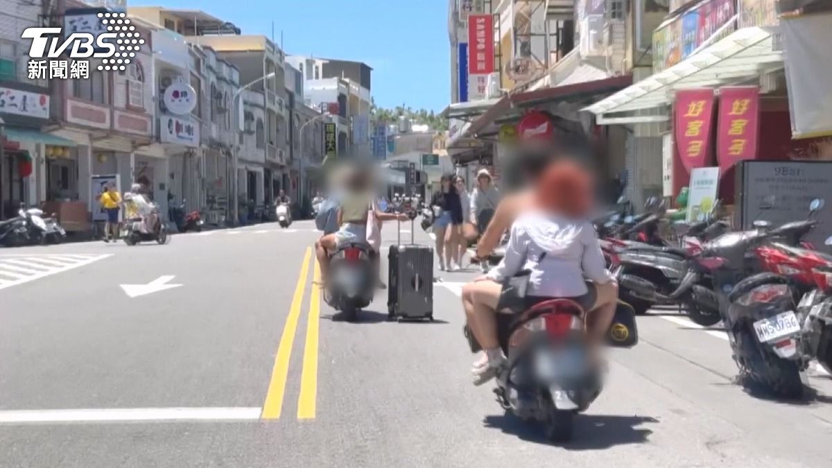 遊客租完機車上路，不只沒戴安全帽，甚至邊騎車、行李一邊拖，讓人看了捏了把冷汗（圖／TVBS）