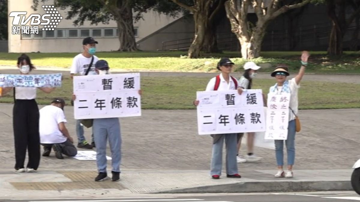 小草在會場外舉牌,盼黨代表大會能夠暫緩兩年條款。(圖/TVBS)