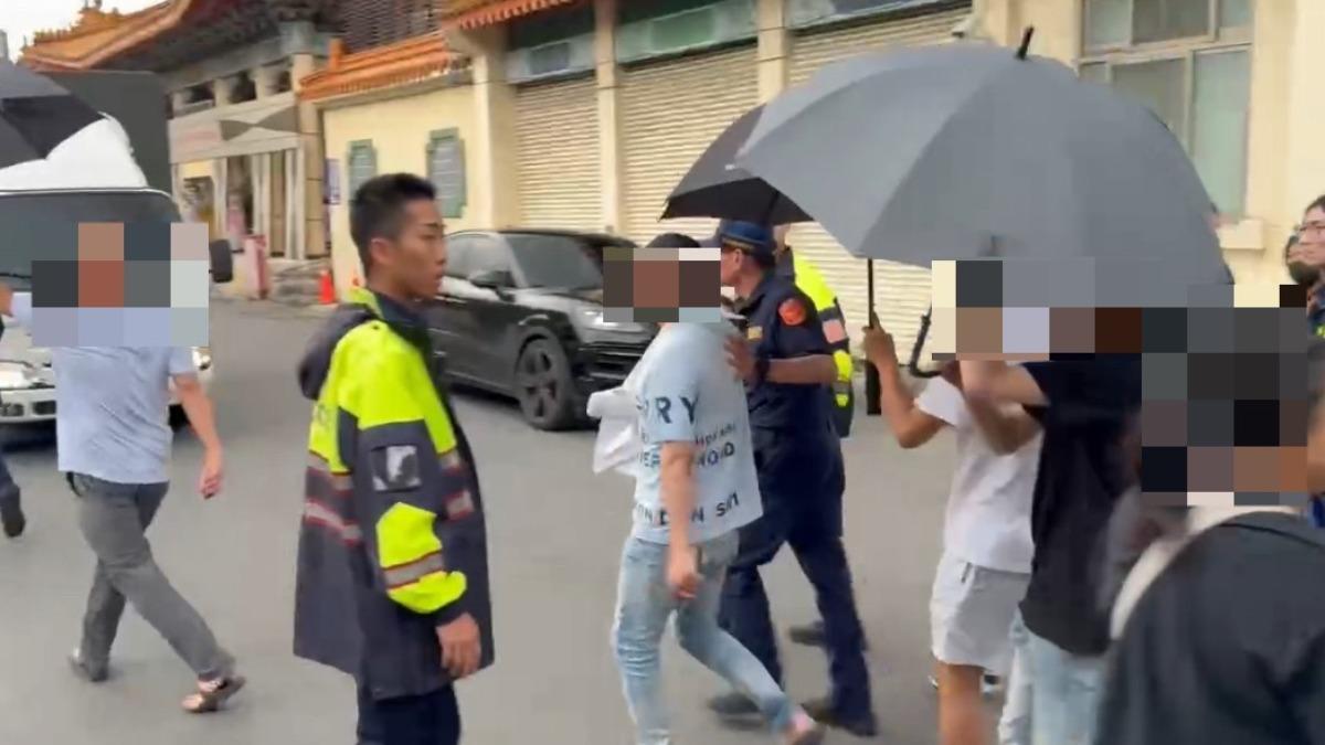 莊男離開時友人幫忙用傘擋住。(圖/翻攝畫面)