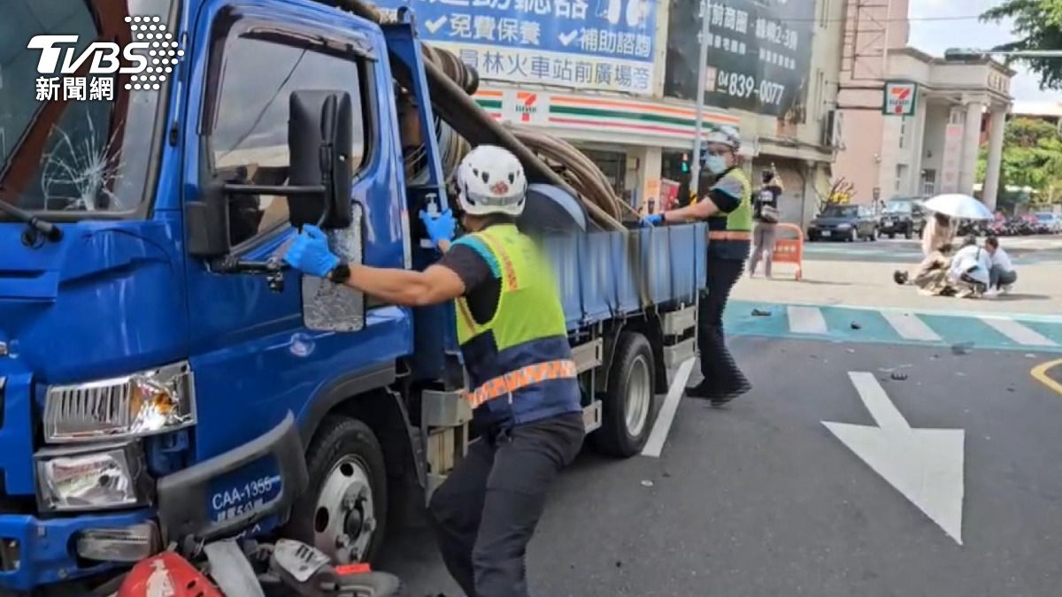 事故現場一片混亂，機車被撞推過路口後卡在車底，安全帽和零件碎片四處飛散。(圖／消防隊提供)